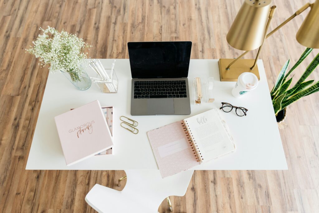 A creative entrepreneur working at a well-organized, dedicated workspace with a laptop and notepad.