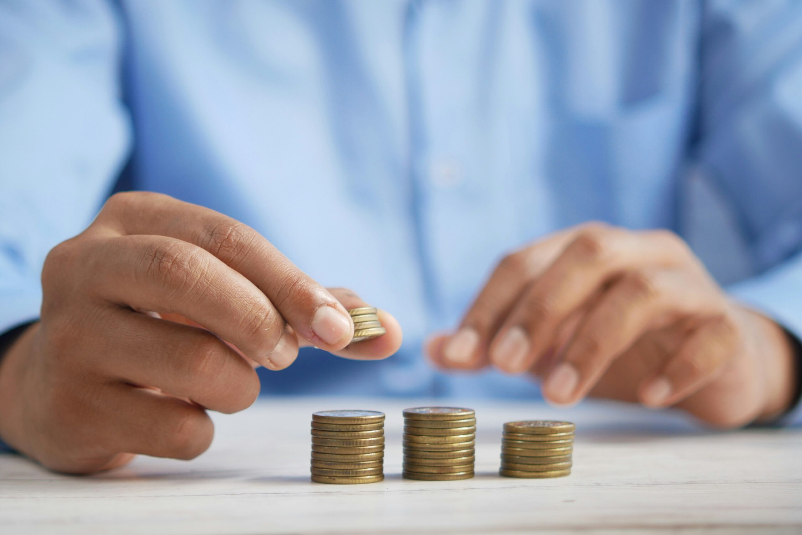 Photo of man counting gold coins.